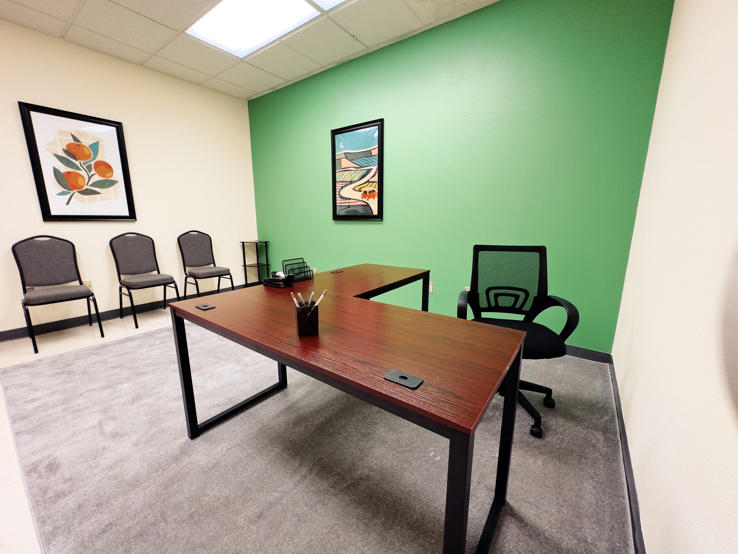 Desk and chairs in an empty office with a green background